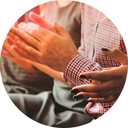 Hombre aplaudiendo, solo se muestran las manos, lleva camisa de cuadros