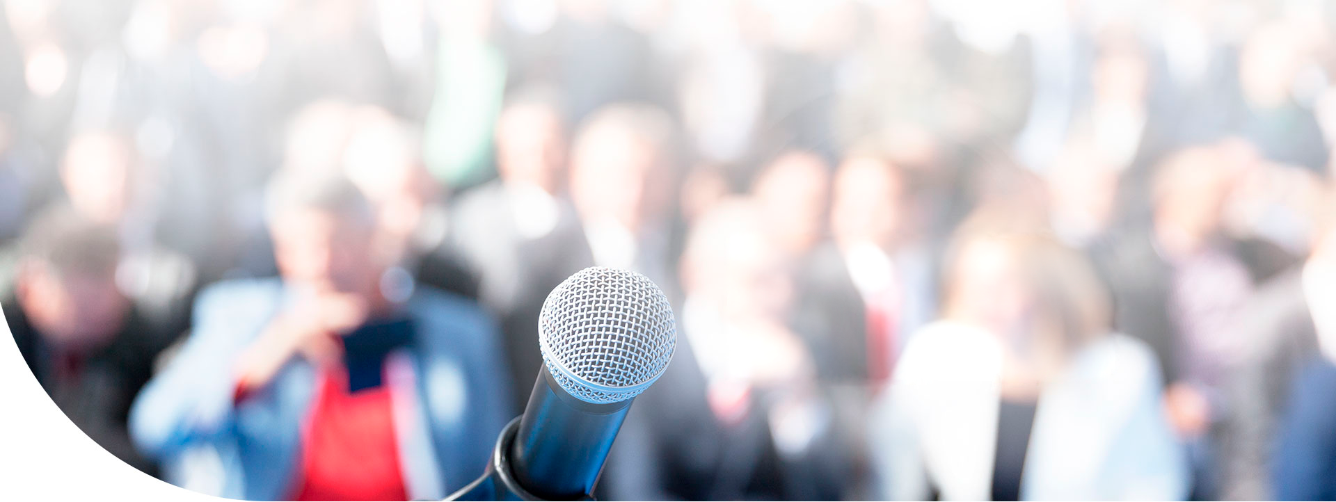 Personas en un evento, adelante sobresale un micrófono